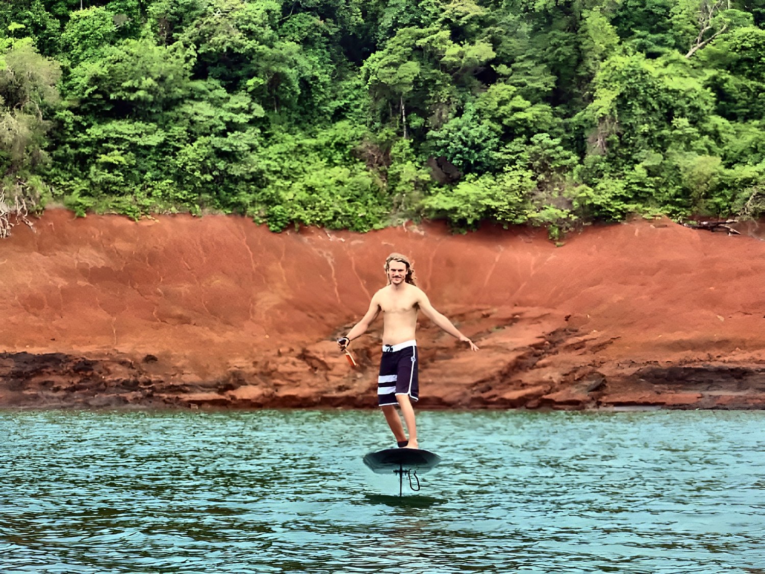 Rider avanzando hacia la cámara con los brazos abiertos sobre el lago